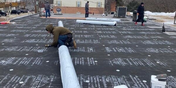 K&J employees wroling on flat top roof